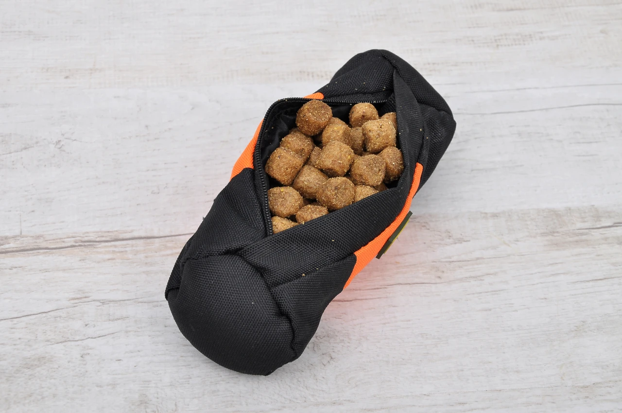 Futterdummy mit duftenen Hunde-Leckerlis befüllen. Der Apportierbeutel hat im besten Fall eine kleine Öffnung. Futterdummy mit Leckerlies für das Dummytraining
