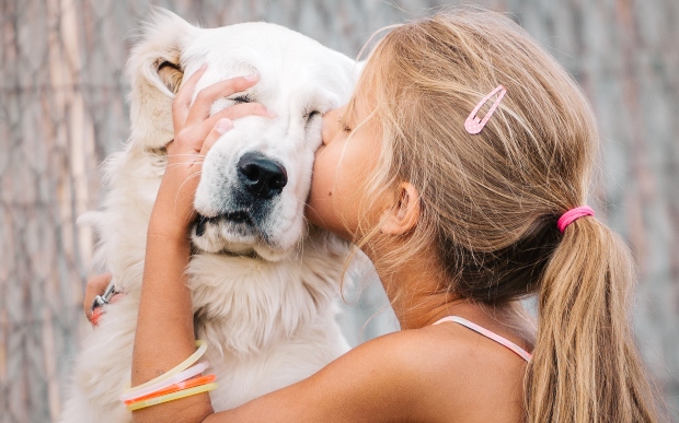 Mädchen umarmt einen Hund