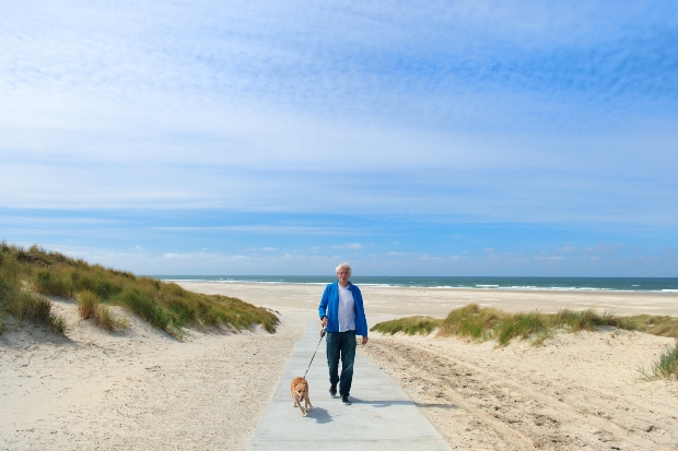 Mann mit Hund am Strand