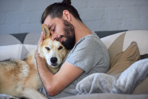 Hund mit Herrchen beim Kuscheln