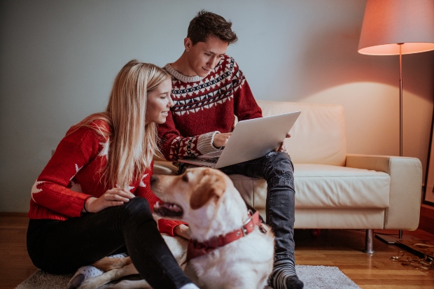 Hund liegt bei Herrchen und Frauchen - Frohe Hundeweihnachten